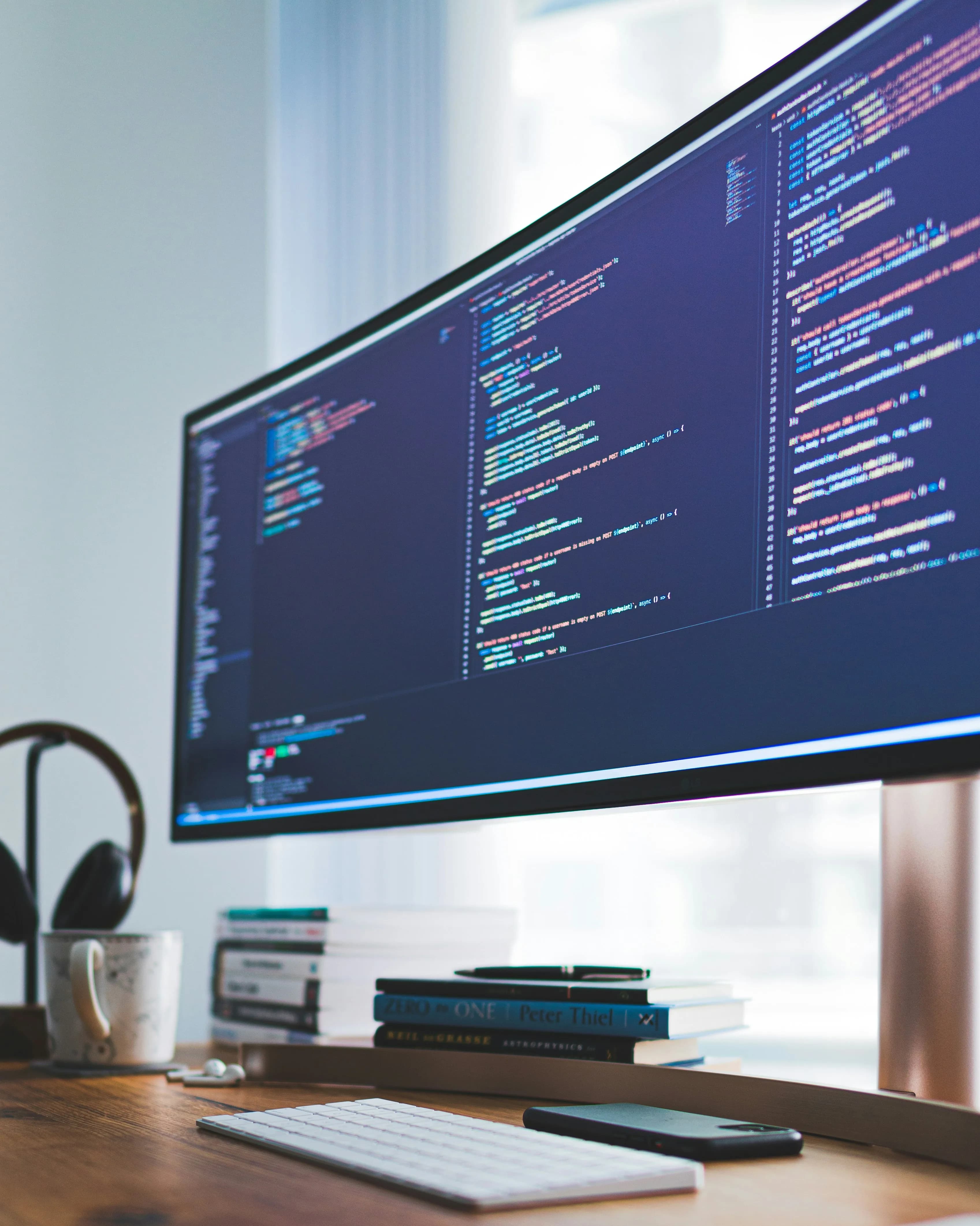 Developer desk with code on an ultrawide monitor